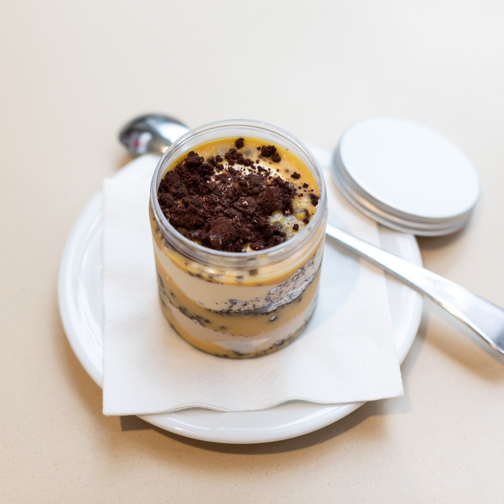 Artisanal jar with coffee parfait and chantilly cream, zabaglione sauce and gluten-free chocolate crumble